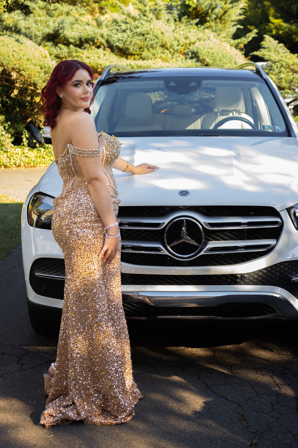 Gold prom portrait in front of a white car